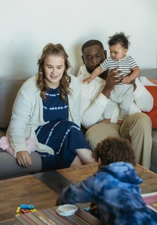 a family sitting on a couch in a living room, diverse outfits, premium quality, alexa grace, samsung smartthings