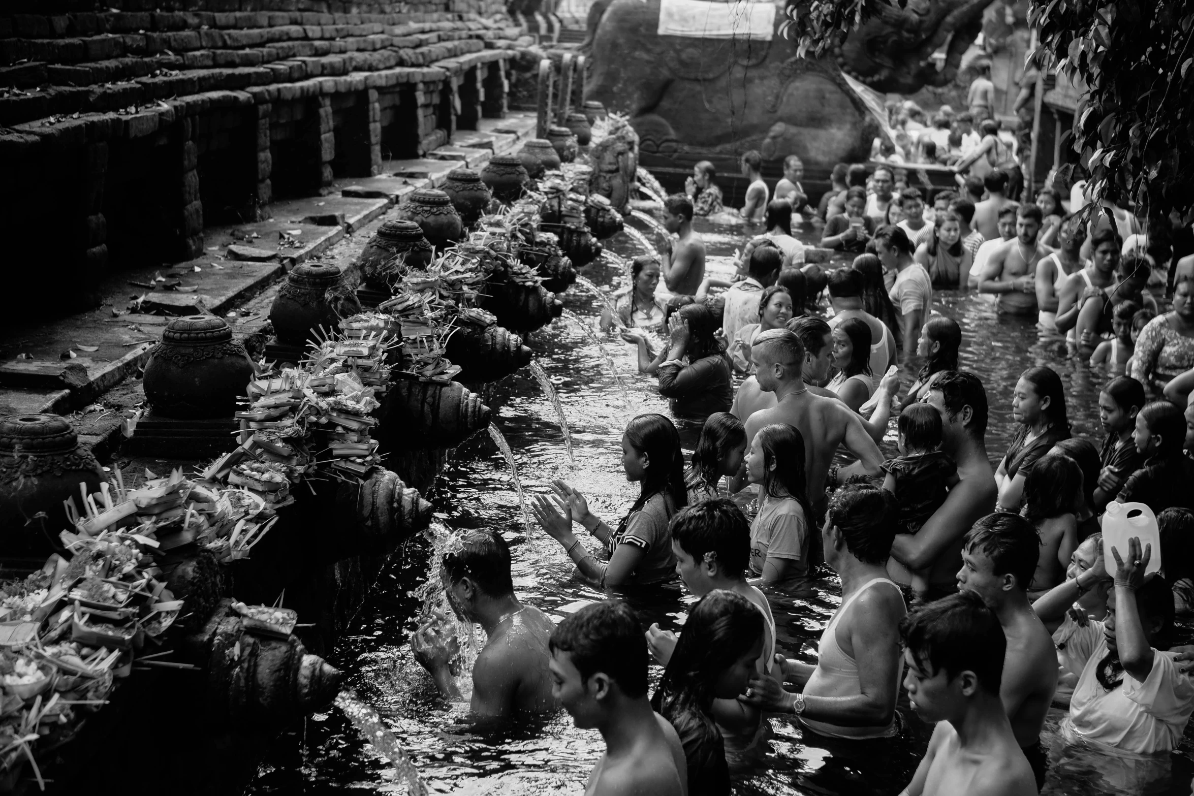 a black and white photo of a crowd of people, a black and white photo, pexels, sumatraism, water temple, baptism, summertime, nagas