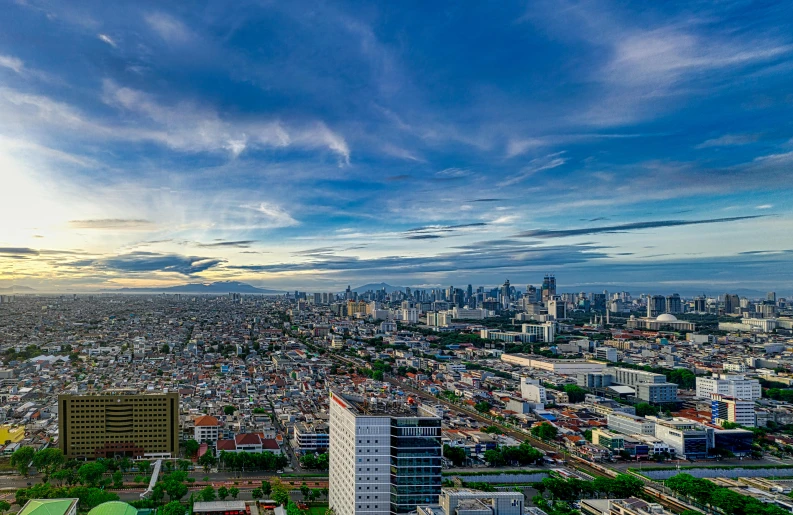 a view of a city from the top of a building, by Niko Henrichon, pexels contest winner, happening, manila, blue and clear sky, slide show, sunset panorama