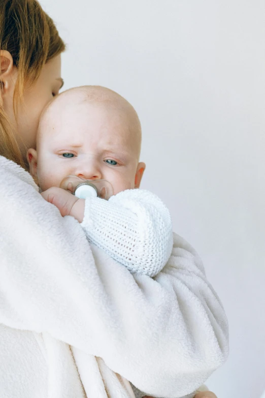 a woman holding a baby in her arms, cold breath, soft but grumpy, very pale skin, holding an epée