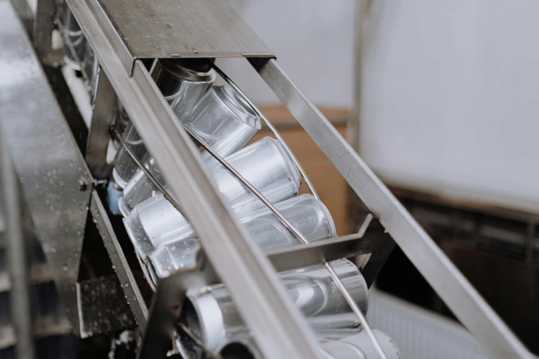 a close up of a conveyor belt in a factory, pexels contest winner, bauhaus, inside a glass jar, silver, cans, slightly tanned