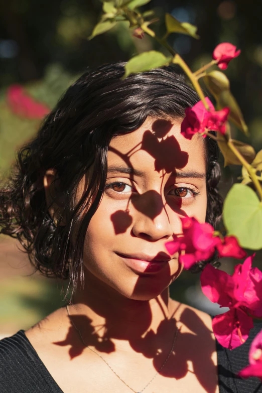 a woman standing in front of a bunch of flowers, an album cover, by Lily Delissa Joseph, pexels contest winner, sunbathed skin, indian girl with brown skin, kids, close up of face