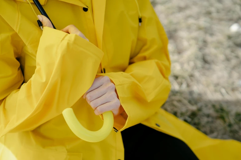 a woman in a yellow rain coat holding an umbrella, inspired by Okada Hanko, unsplash, detail shot, hook as ring, 1 2 0 mm, soft rubber