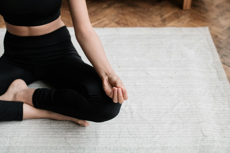 a woman sitting in a yoga position on a rug, trending on pexels, minimalism, black bandage on arms, detailed high resolution, lotus pose, high resolution