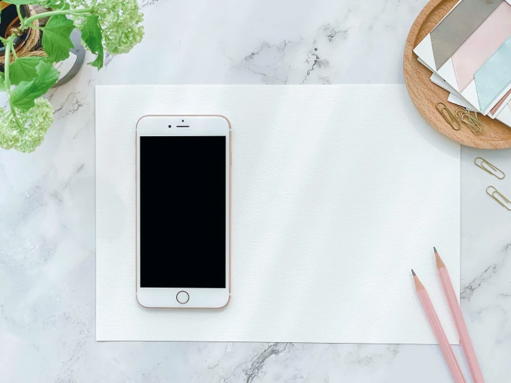 a cell phone sitting on top of a piece of paper, trending on pexels, rectangle white porcelain table, mat drawing paper, wide-screen, white hue