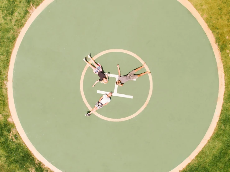 a couple of people standing on top of a baseball field, by Paul Bird, unsplash contest winner, land art, lying on a mandala, southern cross, halo above head, shot on 70mm