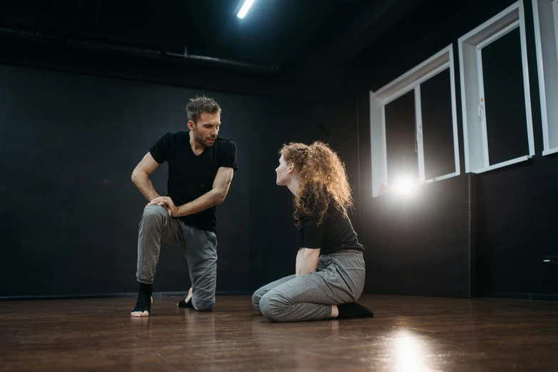 a man and a woman sitting on the floor, by Emma Andijewska, unsplash, art & language, acting, standing in midground, realistic », crouching