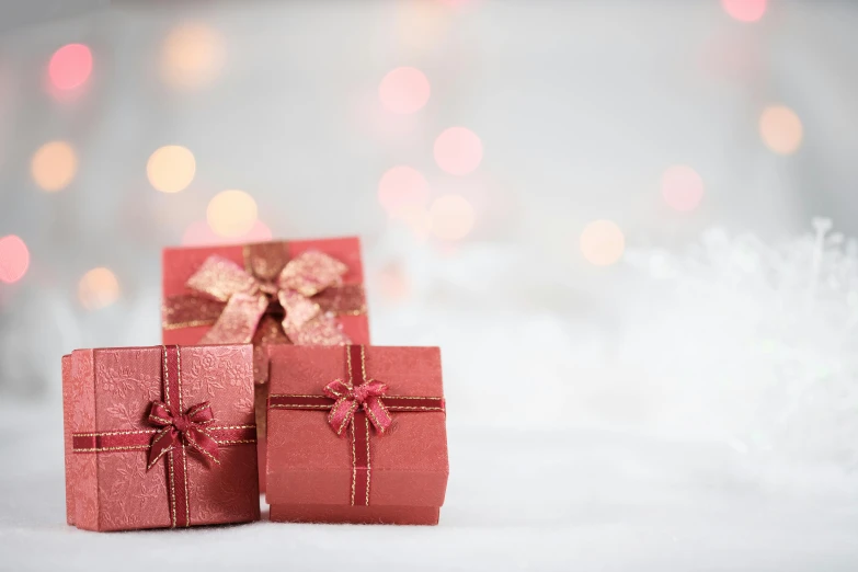 three red gift boxes sitting on top of a snow covered ground, by Emma Andijewska, subtle detailing, pink, blurred, high quality product image”