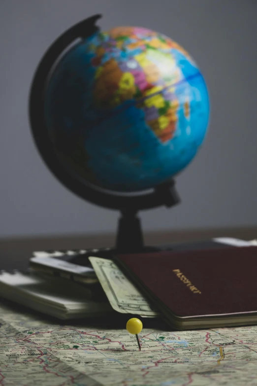 a passport sitting on top of a table next to a globe, thumbnail, sanctuary, multiple stories, low key