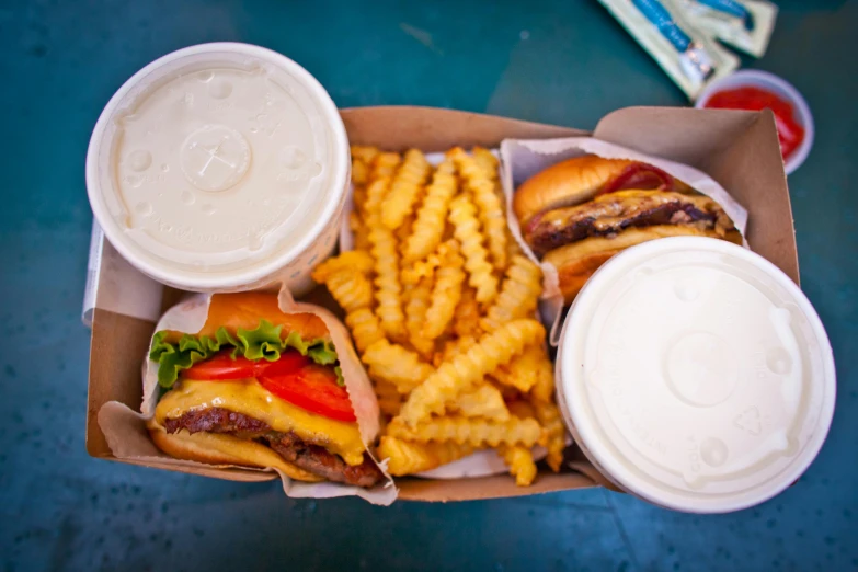 a box of food sitting on top of a table, by Matt Cavotta, pexels, serving burgers, milkshake, striped, burn