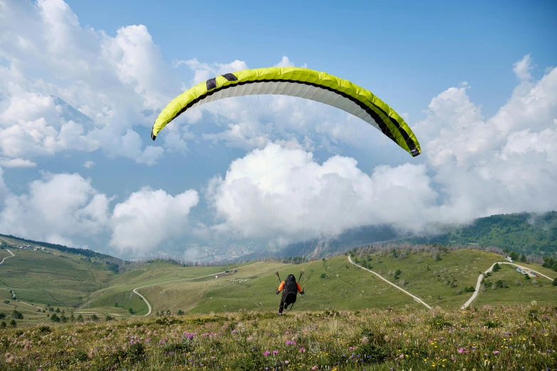 a man standing on top of a lush green hillside, pexels contest winner, figuration libre, parachutes, avatar image, italy, at takeoff