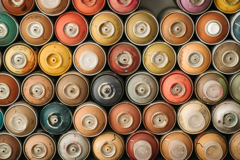 many cans of paint are stacked on top of each other, a photorealistic painting, trending on unsplash, graffiti, vintage style, beads, hairspray, atelier olschinsky