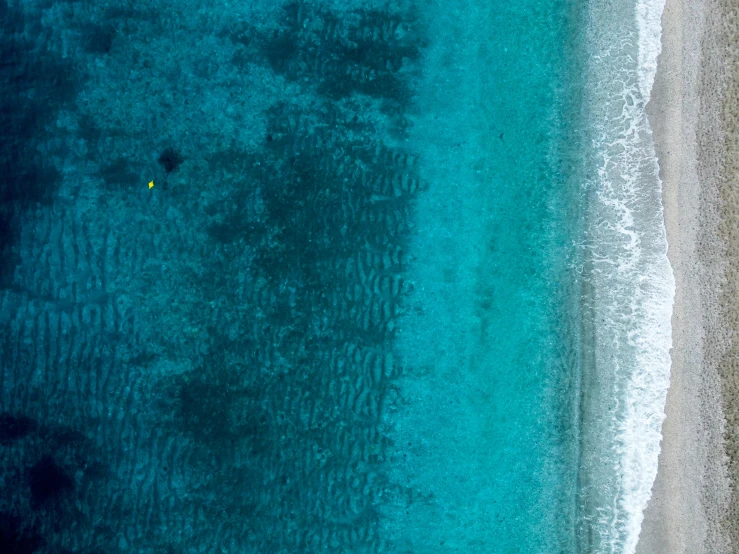 a large body of water next to a sandy beach, a picture, by Adam Marczyński, pexels contest winner, minimalism, yellow and blue and cyan, bird eye view, super detailed image, thumbnail