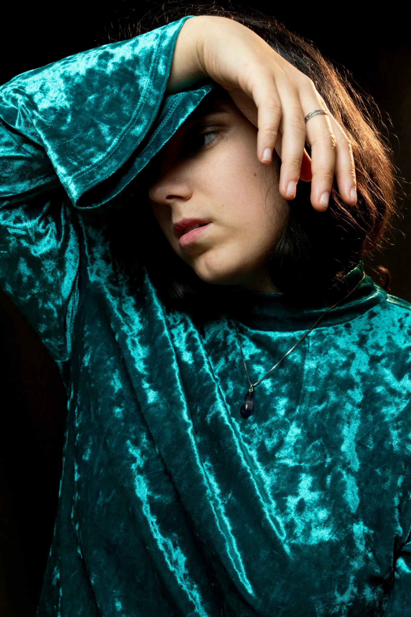 a close up of a person holding a cell phone, an album cover, inspired by Elsa Bleda, private press, dressed in a green robe, portrait androgynous girl, teal, brocade