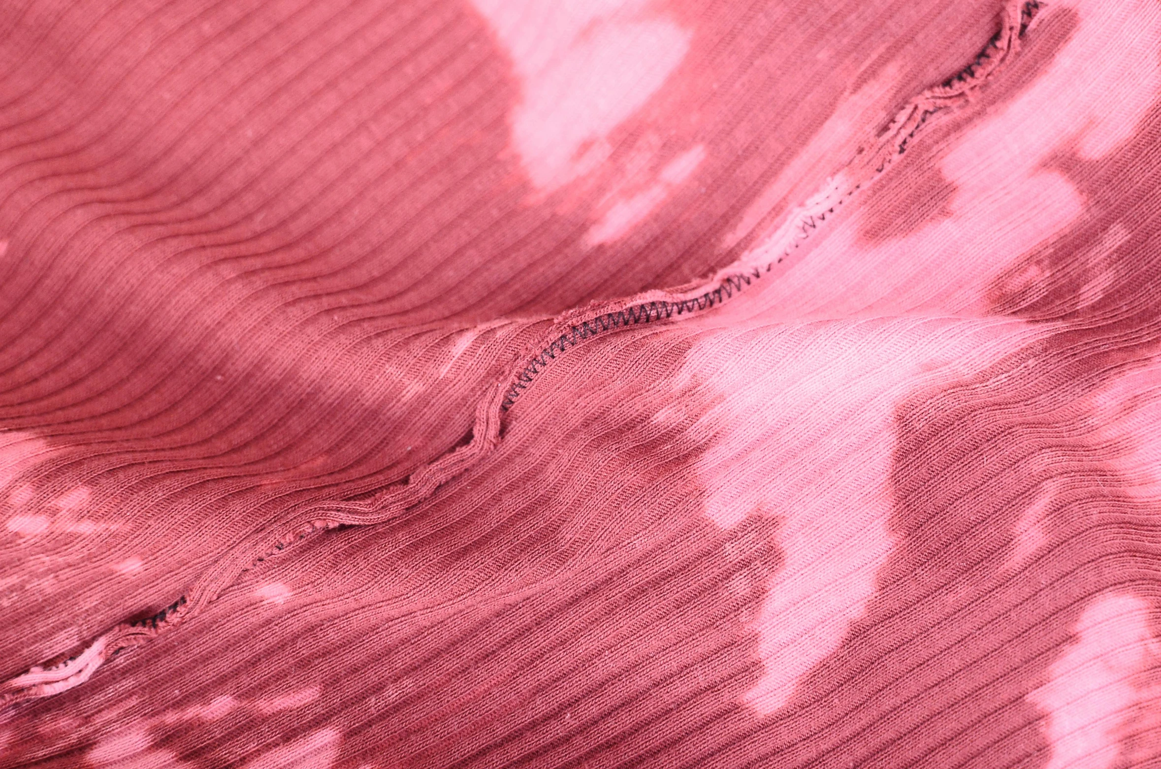 a close up of a pink tie dye shirt, inspired by Edwin Georgi, red torn fabric, visible stitching, highly_detailded, a pair of ribbed