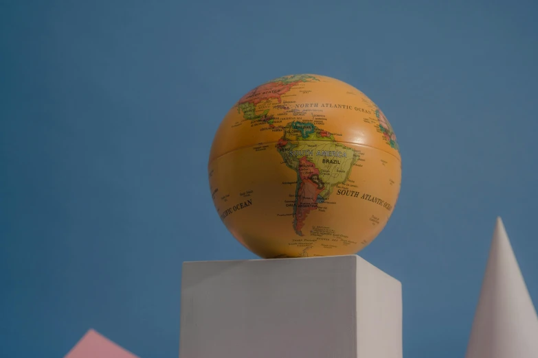 a globe sitting on top of a white pedestal, in the style wes anderson, coloured photo, beige, 3d modelling