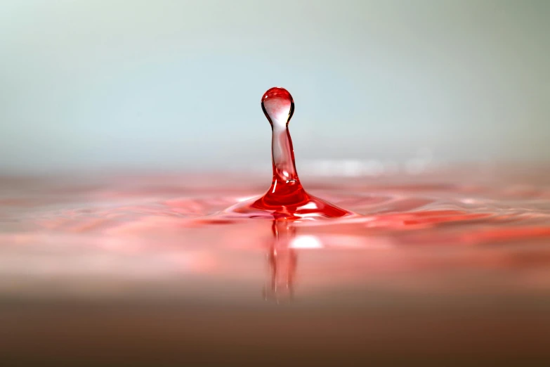 a drop of water sitting on top of a table, a picture, pexels, digital art, red spike aura in motion, avatar image, ground level shot, pools of blood