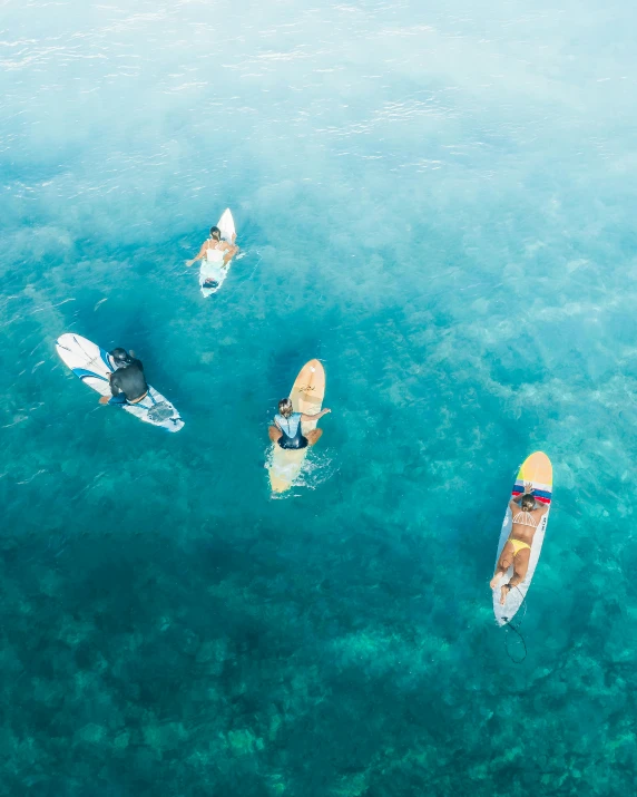 a group of people riding surfboards on top of a body of water, flatlay, clear blue water, thumbnail, some boats