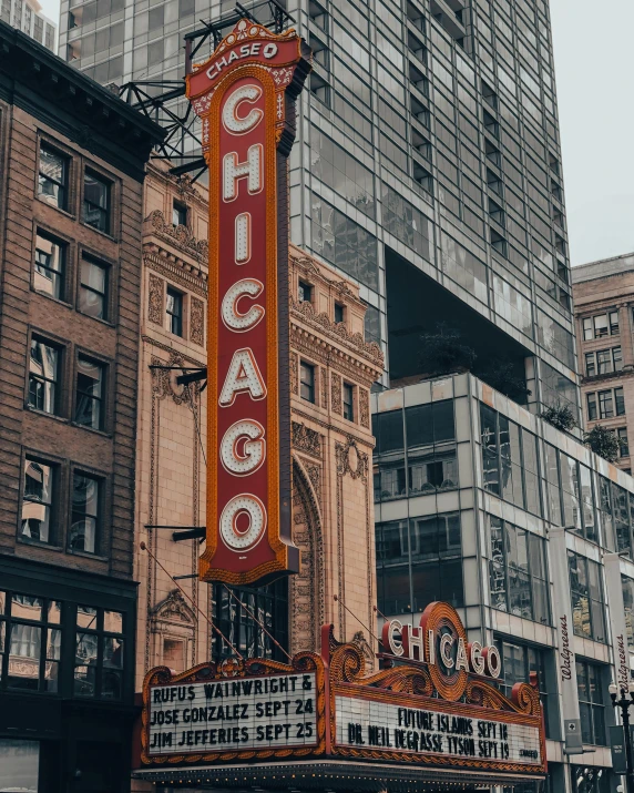 a theater marquee on the corner of a city street, by Robbie Trevino, pexels contest winner, art nouveau, modern chicago streets, promo image, lgbtq, towering over a city