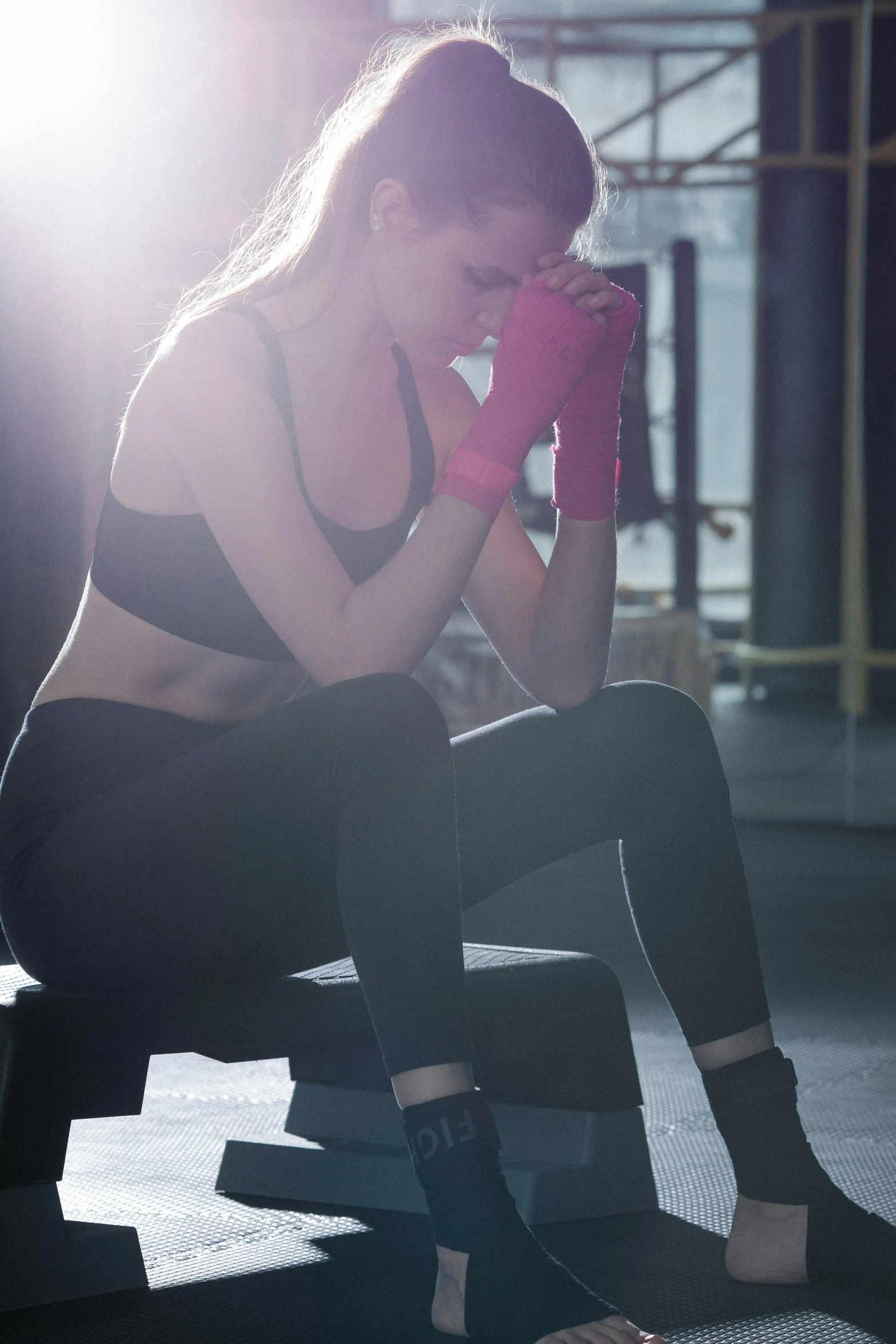 a woman sitting on a bench in a gym, by Alice Mason, shutterstock, frustrated expression, no cropping, cold lighting, fights