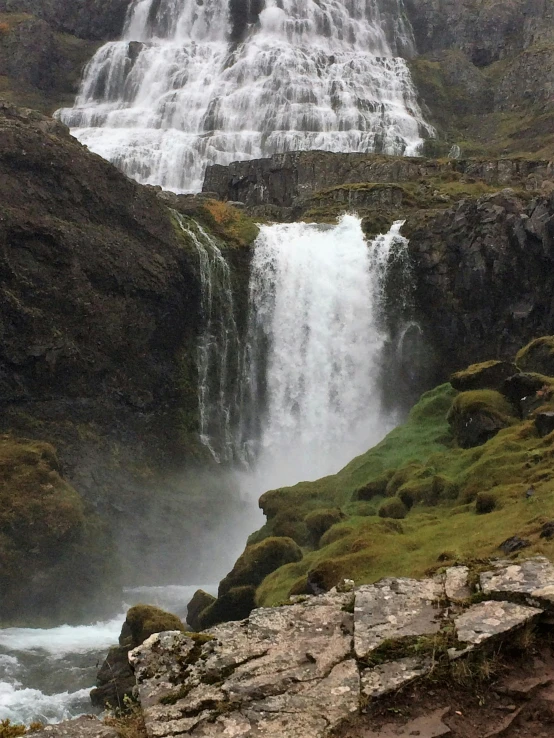 a man standing in front of a waterfall, by Hallsteinn Sigurðsson, pexels contest winner, hurufiyya, moist mossy white stones, panoramic shot, limestone, seen from outside