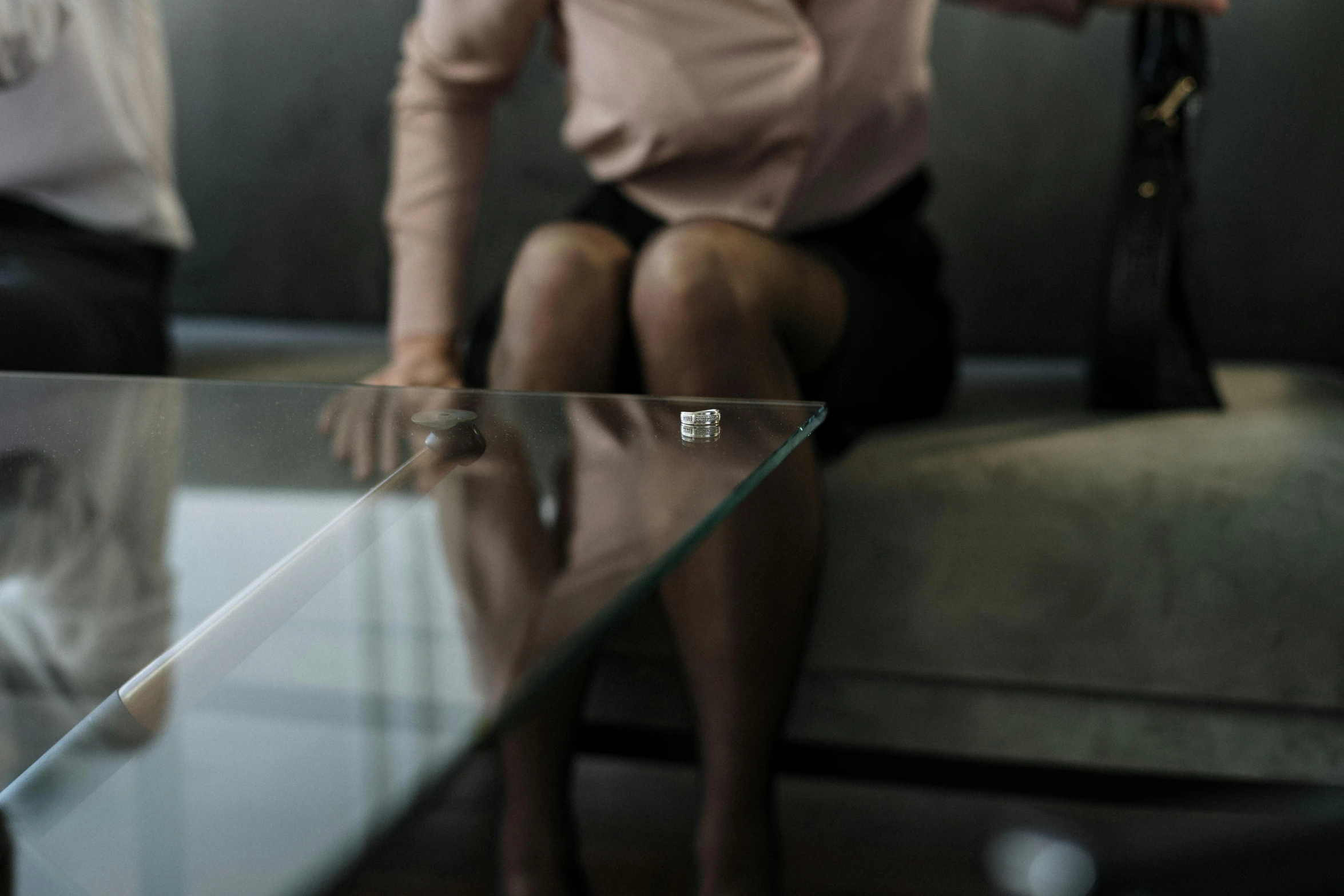 a woman sitting on a couch next to a glass table, pexels contest winner, hyperrealism, macro giantess, female in office dress, engagement ring ads, rectangle