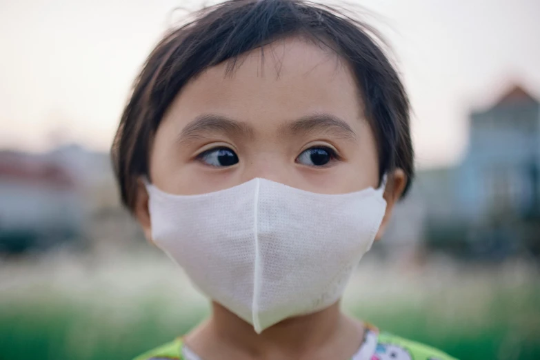 a close up of a child wearing a face mask, inspired by Zhang Kechun, pexels contest winner, clean environment, young asian girl, avatar image, 2010s