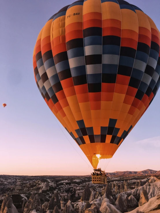 a hot air balloon flying over a rocky landscape, happening, highly upvoted, profile image, landing lights, sunset!