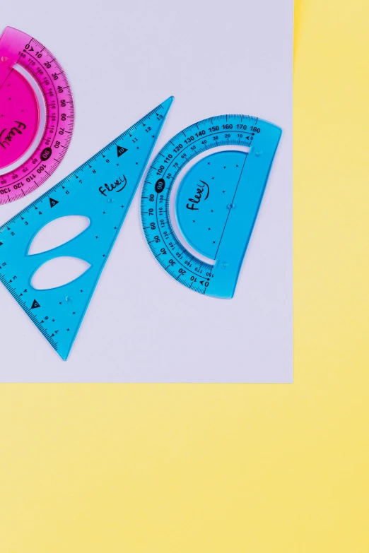 a couple of rulers sitting on top of a table, by Rachel Reckitt, trending on pexels, academic art, turquoise pink and yellow, sierpinski gasket, whiteboards, detail shot