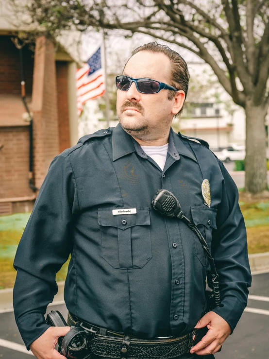 a man in a police uniform standing in a parking lot, by Steve Brodner, sam hyde, profile image, implanted sunglasses, cinematic outfit photo