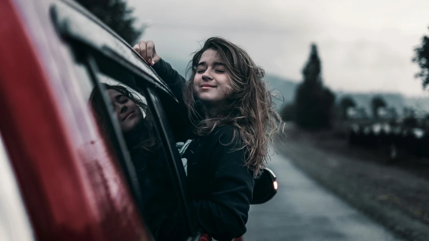 a woman leaning out the window of a car, pexels contest winner, happening, portrait of teenage girl, satisfied pose, avatar image, she has messy hair