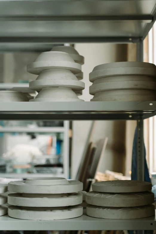 a bunch of plates that are on a shelf, inspired by Peter de Sève, unsplash, process art, in a factory, large jars on shelves, white mechanical details, professional product photo