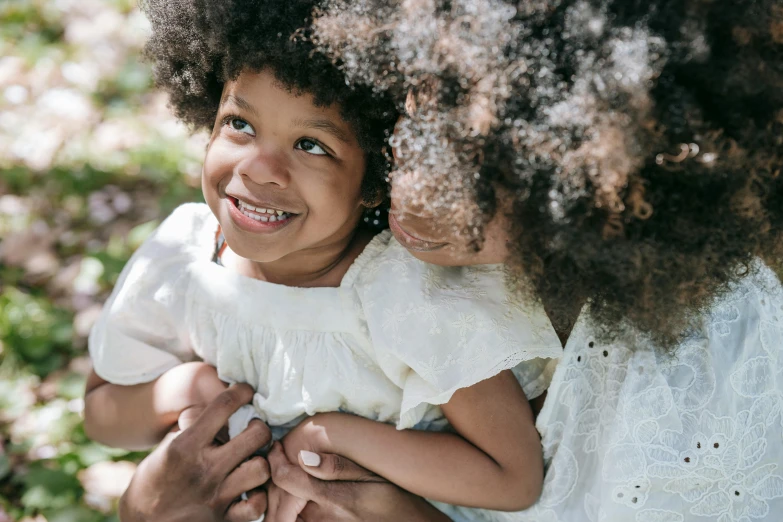 a woman holding a little girl in her arms, pexels contest winner, happening, long afro hair, 4yr old, thumbnail, smiling softly