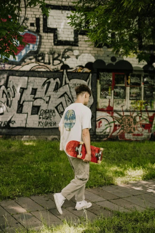 a man walking down a sidewalk with a skateboard, a picture, by Attila Meszlenyi, pexels contest winner, graffiti, portrait of 14 years old boy, promotional image, dasha taran, full body picture