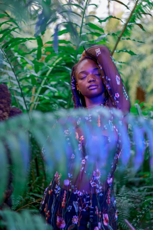 a woman standing in the middle of a lush green forest, an album cover, inspired by Elsa Bleda, trending on pexels, afrofuturism, body covers with neon flowers, black teenage girl, adut akech, doing a hot majestic pose