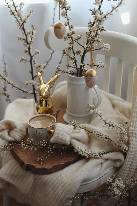 a table topped with a vase filled with flowers, a still life, trending on instagram, hot cocoa drink, bunny, golden ornaments, branches