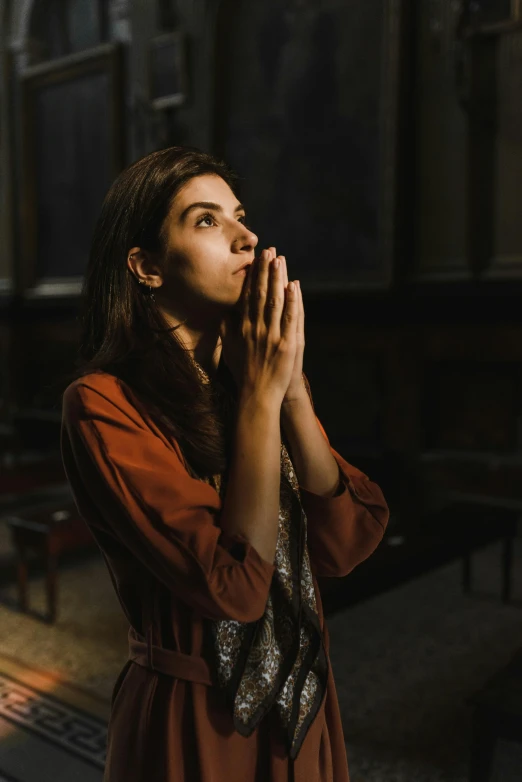 a woman is praying in a church, inspired by Elsa Bleda, pexels, mahira khan as a mage, dua lipa, brown, student