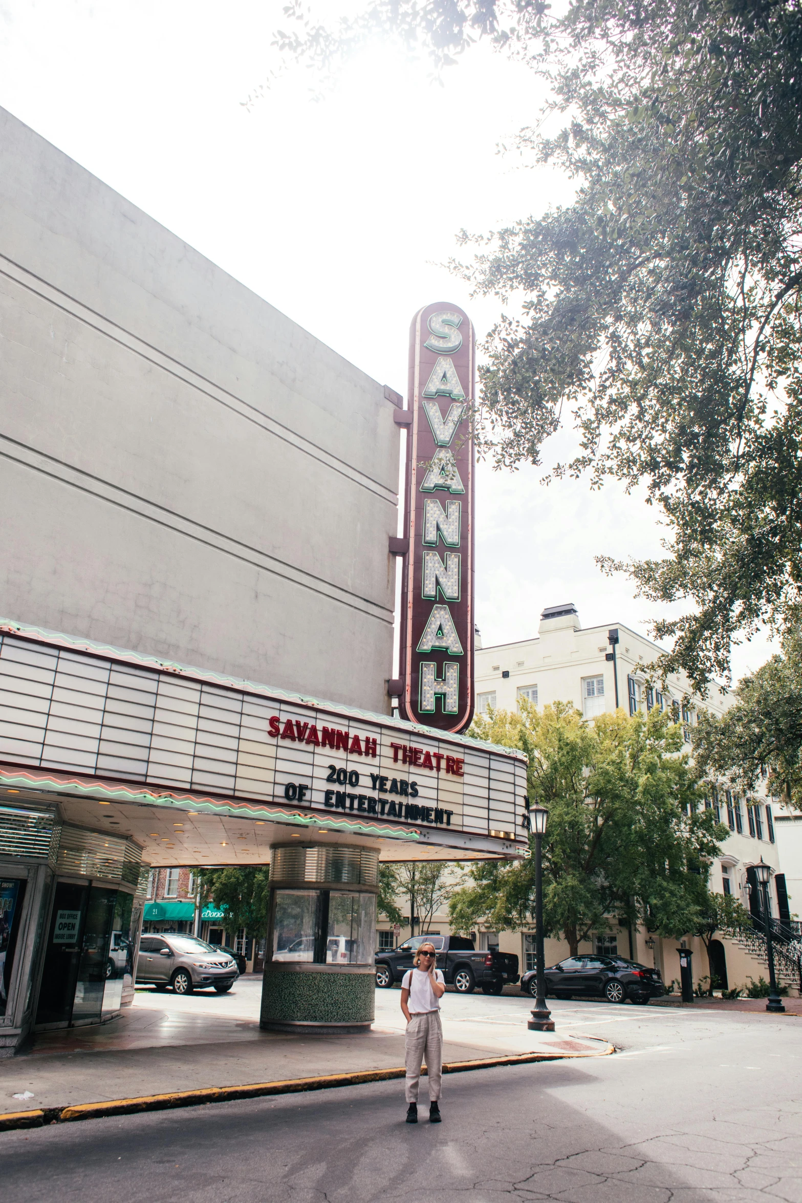 a man standing in front of a movie theater, running in savannah, square, information, exterior