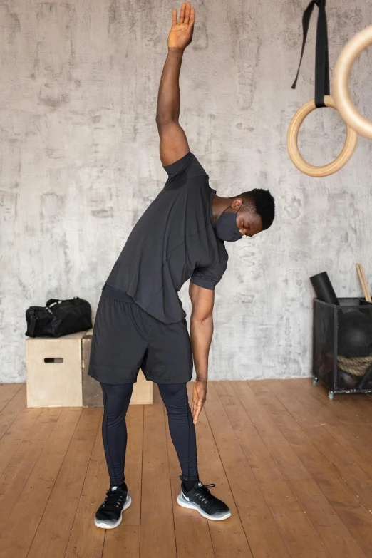 a man doing a handstand exercise in a gym, by James Morris, pexels contest winner, renaissance, wearing a mask, man is with black skin, portrait of tall, profile image