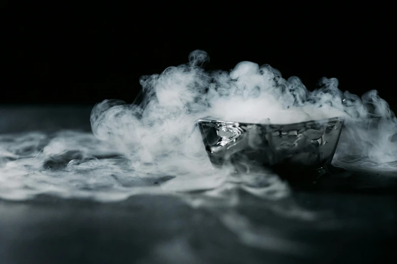 a bowl filled with smoke sitting on top of a table, inspired by Carrie Mae Weems, trending on unsplash, process art, made of liquid metal, steamboat willy, close - up photograph, made out of shiny silver