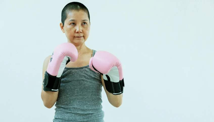 a woman in a gray tank top and pink boxing gloves, by Natasha Tan, pexels contest winner, a bald, 5 5 yo, jia ruan, surgery