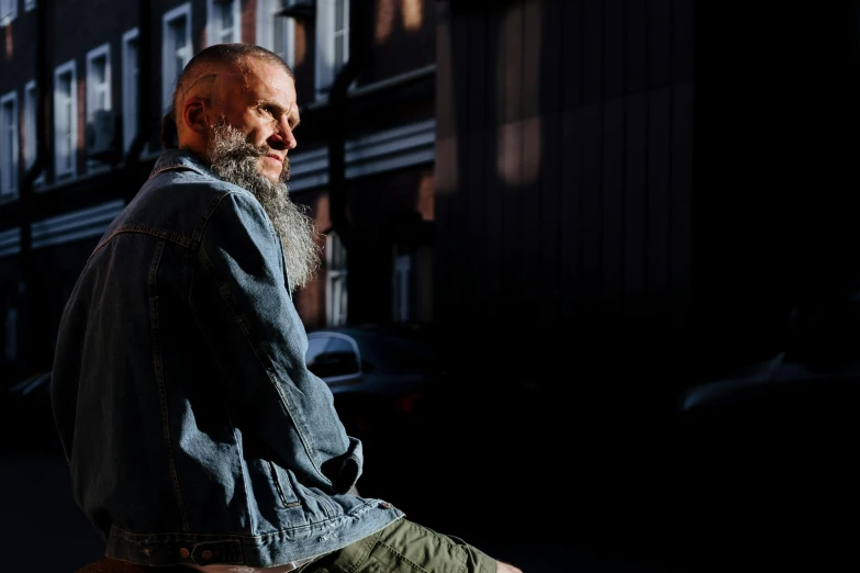 a man with a long beard sitting on a bench, by Jan Tengnagel, unsplash, hyperrealism, in front of a garage, sun shining, profile image, shot on hasselblad