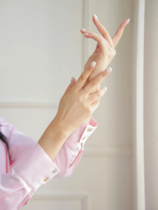 a woman standing in front of a window with her hands in the air, trending on pexels, white and pink cloth, close-up of thin soft hand, porcelain skin ”, acupuncture treatment