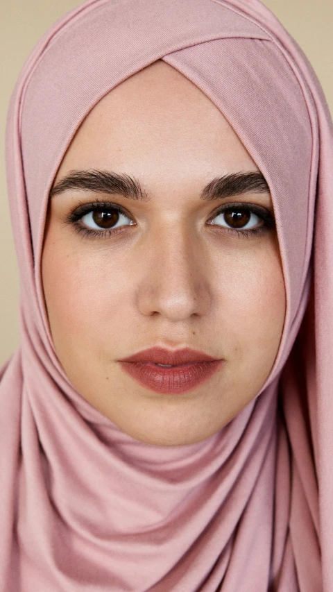 a woman wearing a pink hijab, inspired by Maryam Hashemi, trending on pexels, real human face, dua lipa, muted brown, simetrical medium shot