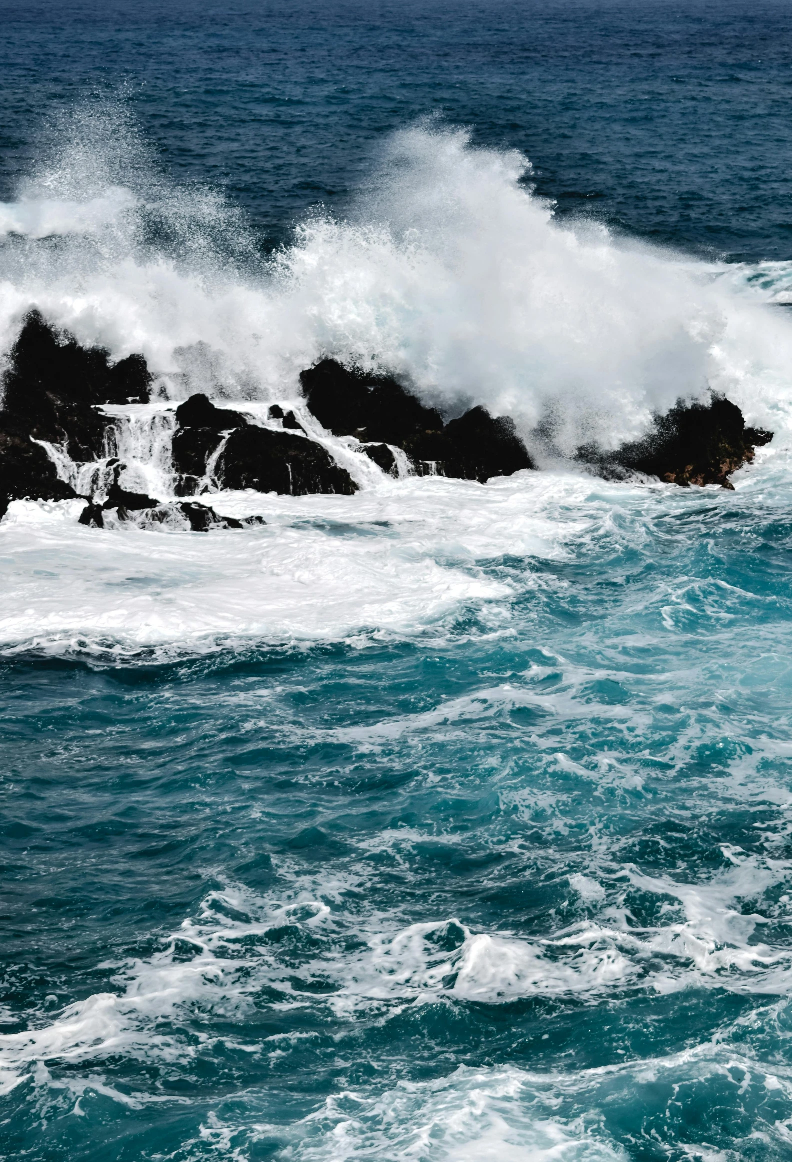 a man riding a surfboard on top of a wave in the ocean, jagged rocks, slide show, tumultuous, cerulean