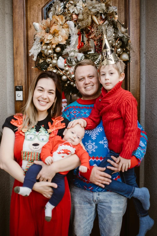 a family poses for a picture in front of a christmas tree, by Julia Pishtar, red and blue garments, 30 year old man, thumbnail, avatar image