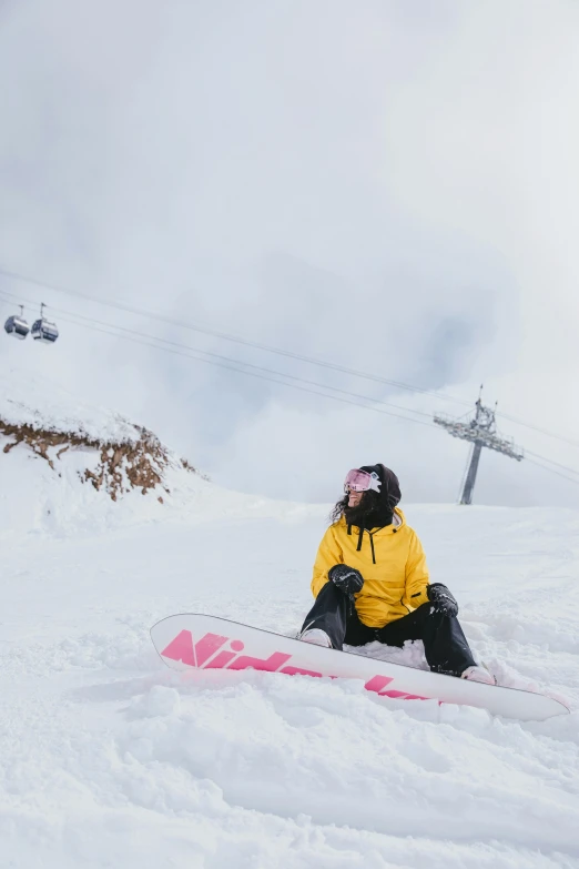 a person sitting in the snow on a snowboard, by Winona Nelson, trending on unsplash, new zealand, sports illustrated, yellow, sitting in a fluffy cloud