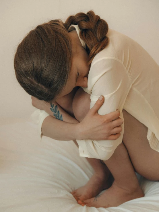 a woman hugging a baby on top of a bed, a tattoo, trending on pexels, non binary model, sorrow, gif, pillows