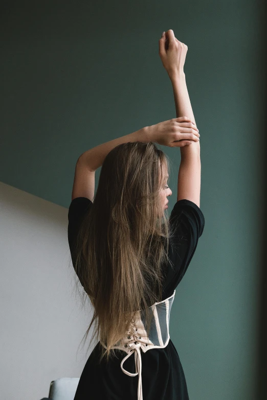 a woman in a black dress standing in front of a window, inspired by Elsa Bleda, trending on unsplash, renaissance, long ashy hair | gentle lighting, playful pose of a dancer, pictured from the shoulders up, dark blond long hair