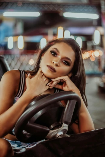 a woman sitting in the driver's seat of a car, an album cover, trending on pexels, isabela moner, amusement park, street night, non binary model